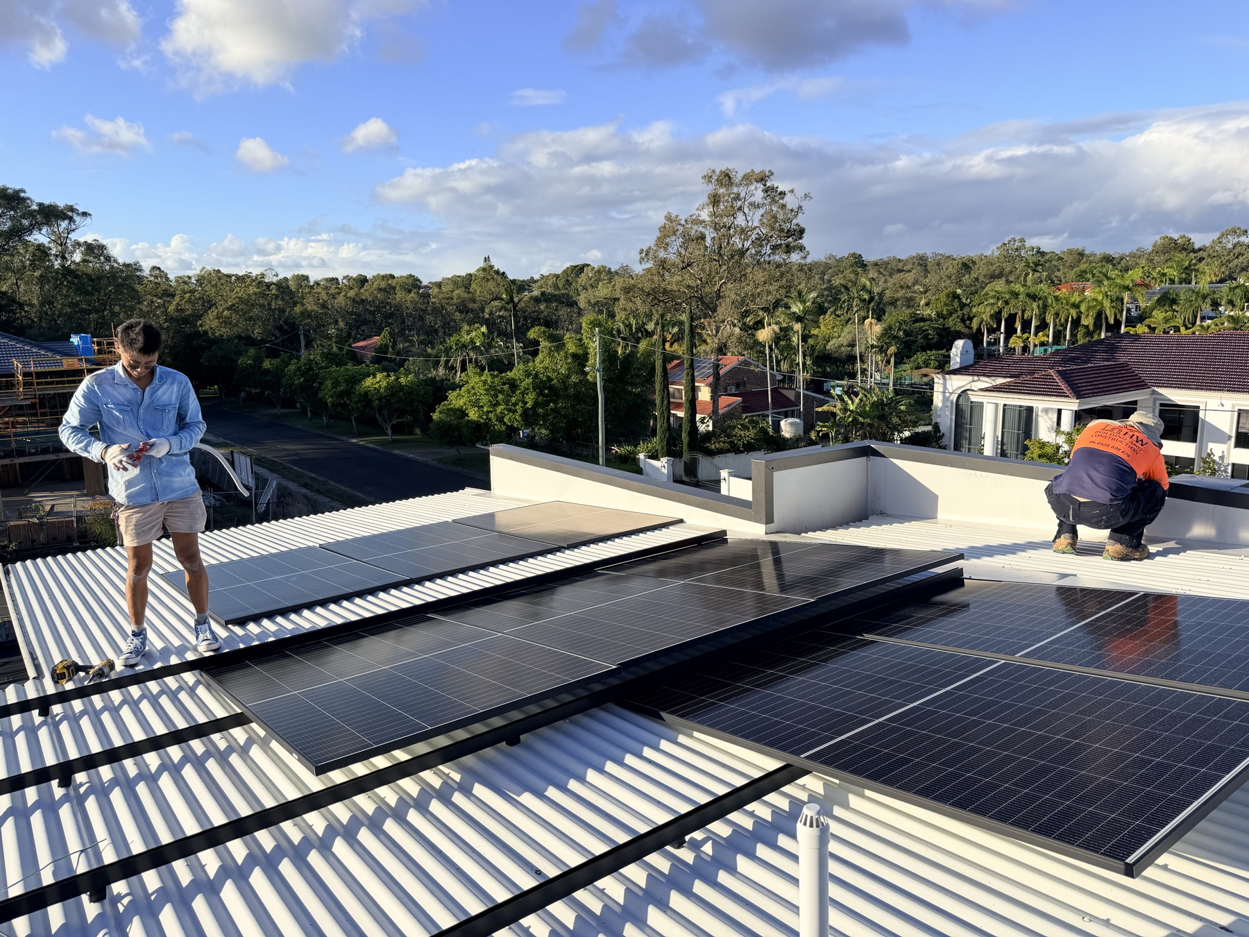 Installers laying panels across the rooftop array